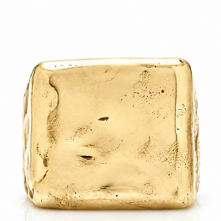 A square gold ring with a heavily textured, organic, hammered surface, photographed on a clean white background with a soft reflection below.