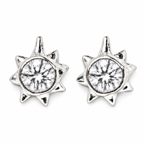 A pair of silver starburst stud earrings with round clear gemstones, shown on a plain white background.