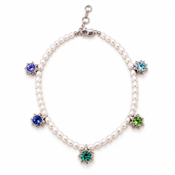 A pearl necklace with silver-toned settings and five colorful gemstone flower-shaped charms in blue, green, and light blue, displayed on a clean white background.