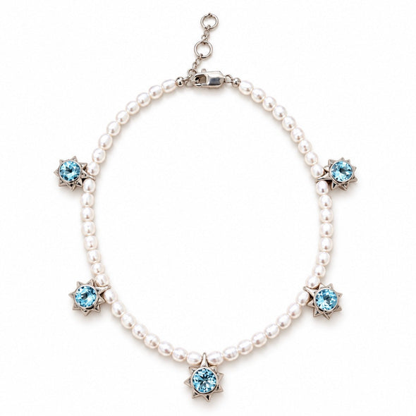 A pearl necklace with five star-shaped silver settings, each holding a light blue gemstone, displayed on a clean white background.