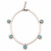 A pearl necklace with five star-shaped silver settings, each holding a light blue gemstone, displayed on a clean white background.