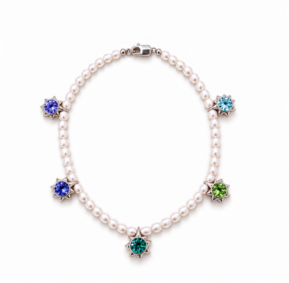 A pearl necklace with five starburst-shaped gemstone settings in silver-toned metal, featuring blue, green, and purple stones on a white background.