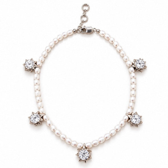 A pearl necklace with five star-shaped diamond clusters set in silver-toned metal, displayed on a clean white background.