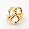 A gold ring designed in the shape of a pretzel, featuring a polished, textured finish on a clean white background.