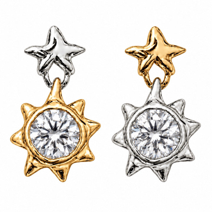 Two star-shaped dangle earrings on a plain white background. Each earring has a smaller star at the top and a larger sunburst-shaped pendant with a round clear gemstone in the center.