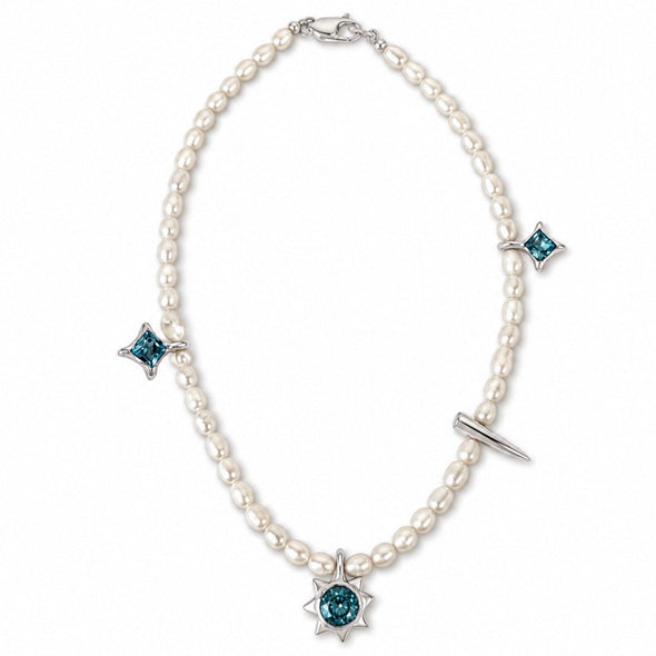 A pearl necklace with a silver-tone starburst pendant featuring a round teal gemstone, accented with three matching starburst charms and a small silver bar detail, shown on a plain white background.