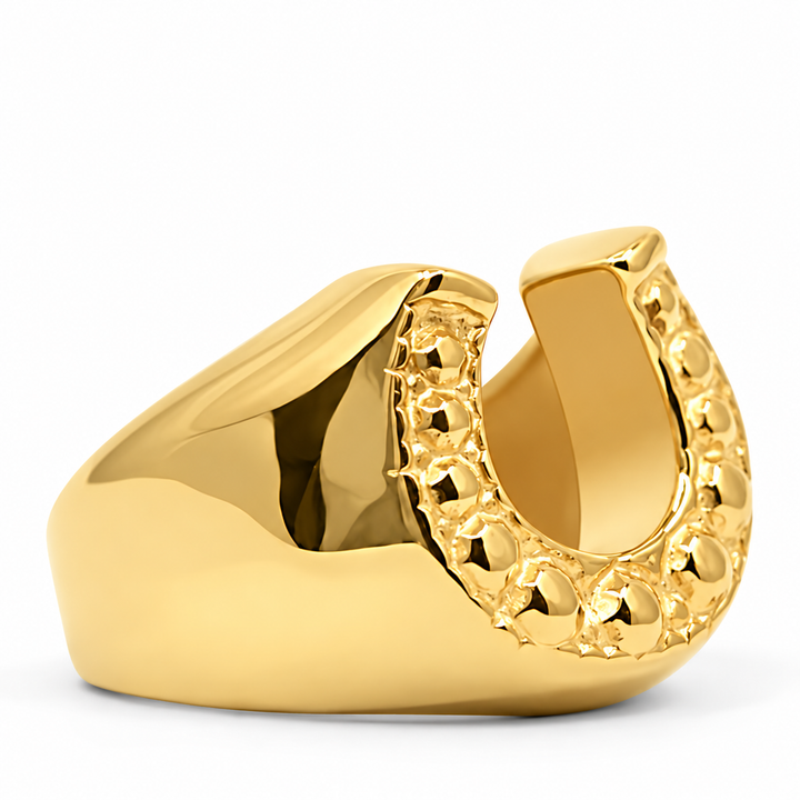 A polished gold horseshoe-shaped mouthguard or dental mouthpiece with a textured beaded edge, shown on a clean white background.
