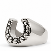 A polished silver horseshoe-shaped ring with textured, oxidized detailing along the outer edges, shown on a clean white background.