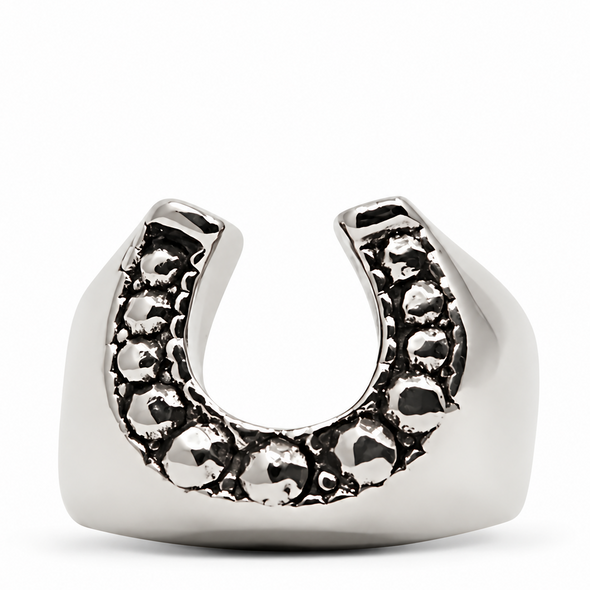 A silver horseshoe-shaped ring with a textured, dark oxidized pattern along the top curve, set against a plain white background.