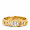 A yellow gold ring featuring a marquise-cut diamond center stone and three smaller round diamonds set in a textured, organic-shaped band, shown on a plain white background.