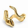 A sculptural abstract gold ring with a polished, fluid, wavy design, shown on a clean white background.