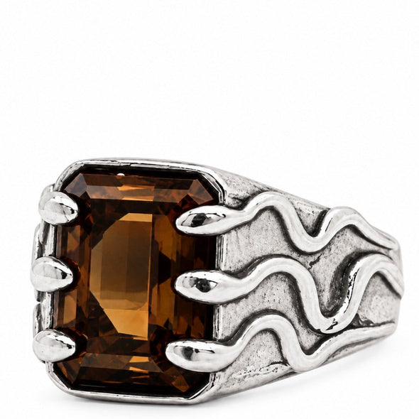 A silver-toned ring featuring a large rectangular brown smoky quartz gemstone, with a textured band designed to look like stylized flames, photographed on a solid white background.