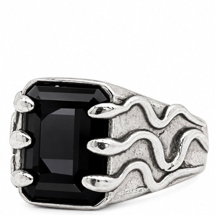 A silver ring with a large rectangular black gemstone and a textured, wavy flame-like design on the band, shown against a plain white background.