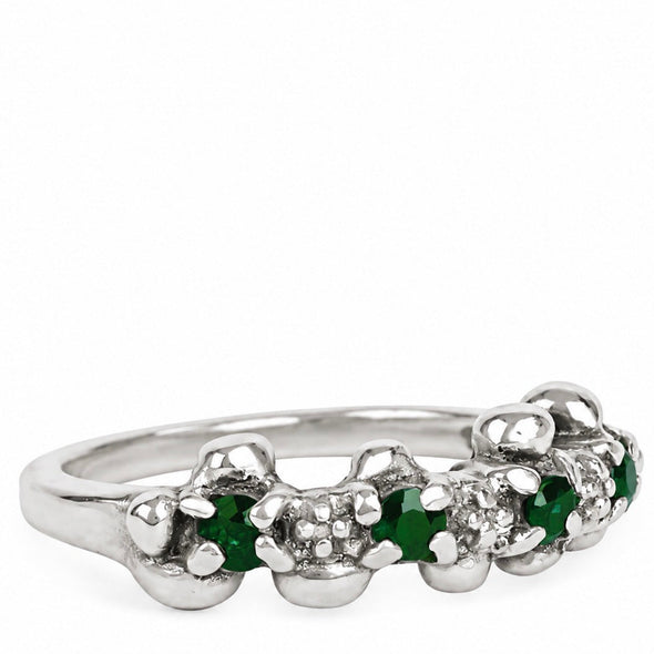A silver flower-shaped ring featuring green emerald-cut gemstones and small clear accent stones, shown on a plain white background.