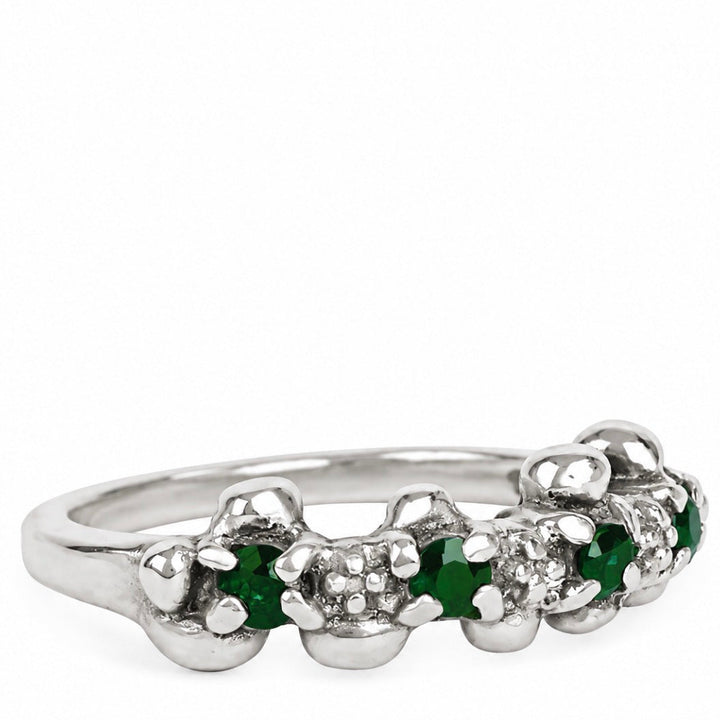 A silver flower-shaped ring featuring green emerald-cut gemstones and small clear accent stones, shown on a plain white background.