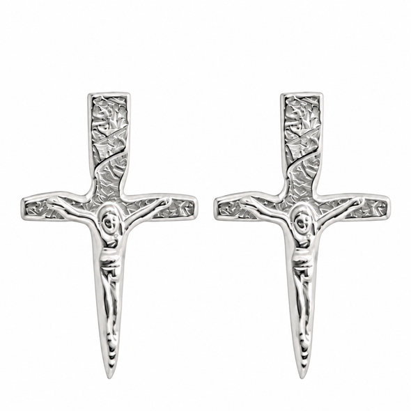 A pair of silver crucifix stud earrings with a textured, hammered finish and a detailed figure of Jesus on a plain white background.