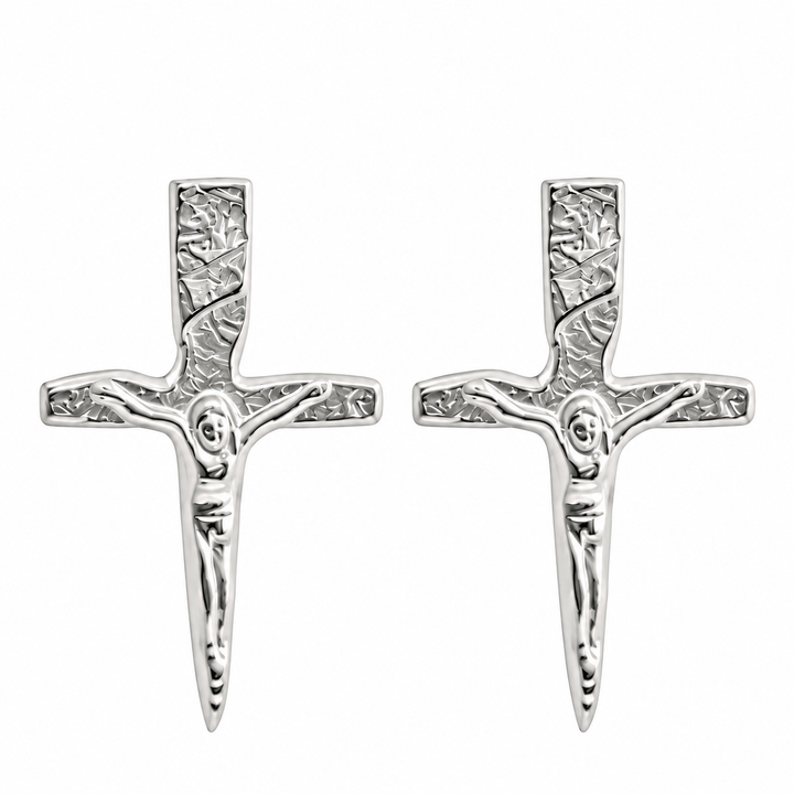 A pair of silver crucifix stud earrings with a textured, hammered finish and a detailed figure of Jesus on a plain white background.