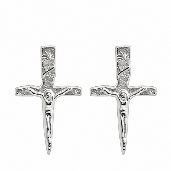 A pair of silver crucifix stud earrings with detailed engravings, shown side-by-side on a plain white background.