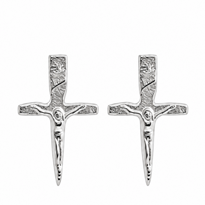 A pair of silver crucifix stud earrings with detailed engravings, shown side-by-side on a plain white background.