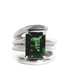 Silver ring with a green gemstone on a white background