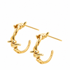 A pair of gold huggie hoop earrings with a twisted, knotted barbell-inspired design, shown on a plain white background.