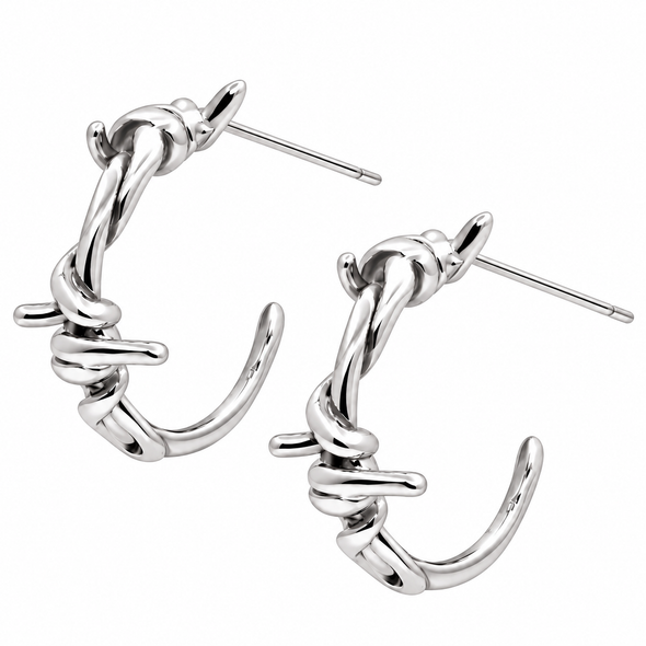 A pair of polished silver hoop earrings with a twisted, barbed-wire-inspired design and straight post backings, shown on a plain white background.