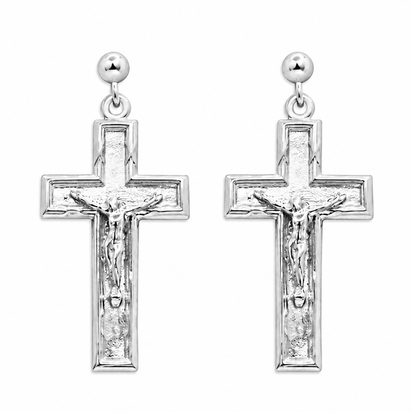 A pair of silver crucifix dangle earrings with textured cross pendants, featuring a detailed corpus and a small round ball stud at the top, shown against a plain white background.