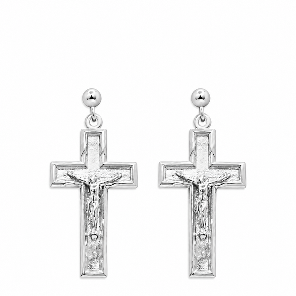 A pair of silver crucifix dangle earrings with a textured cross design featuring a detailed corpus, suspended from round silver studs on a plain white background.