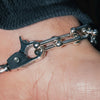 Close-up of a silver bracelet on a wrist with a blurred background