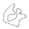 A silver necklace featuring a barbed wire link design with asymmetrically placed pendants on a cable chain.