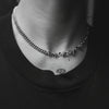 Necklace with barbed wire design worn by a person against a black background