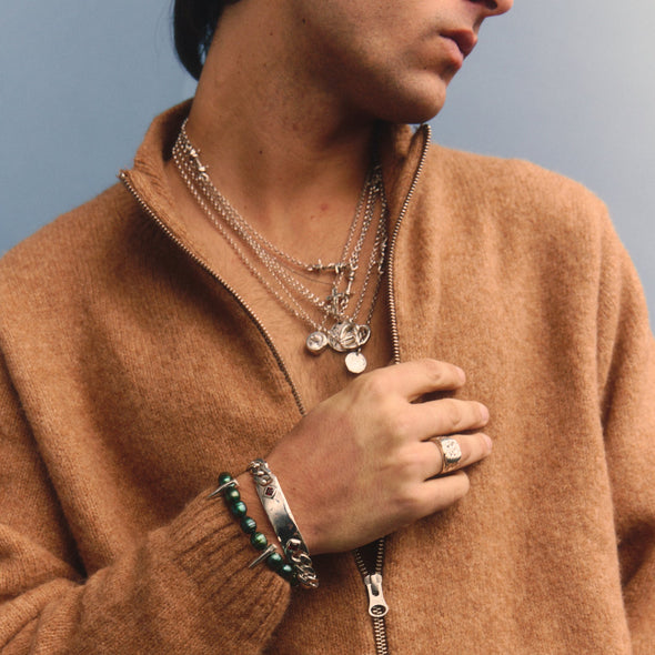 Person wearing a brown zip-up sweater against a blue background