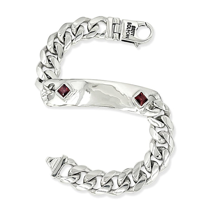 Silver bracelet with red gemstones on a white background