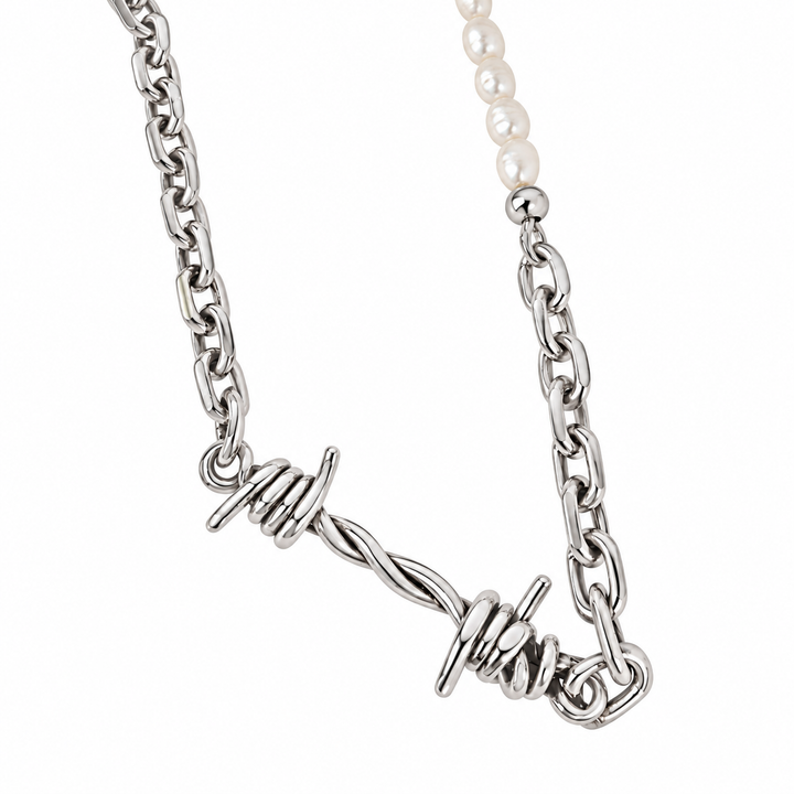 A silver-toned chain necklace featuring a twisted barbed wire pendant and a section of white pearl beads, shown against a plain white background.