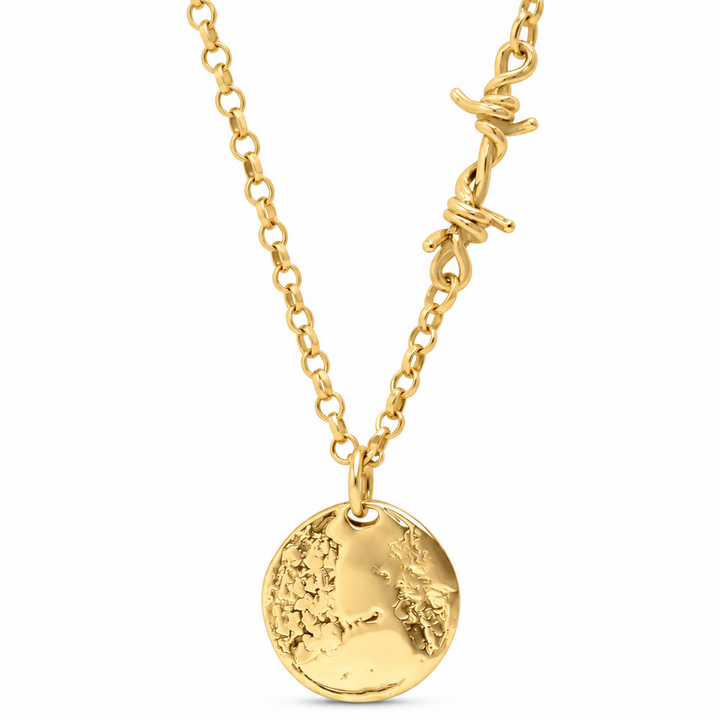A gold chain necklace featuring a textured round pendant with embossed map details and a barbed wire accent on the chain, shown against a plain white background.