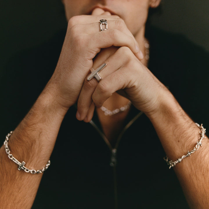 Person wearing jewelry including rings and bracelets.