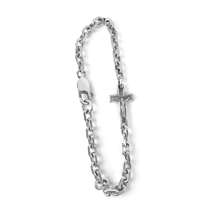 Silver chain bracelet with a cross charm on a white background