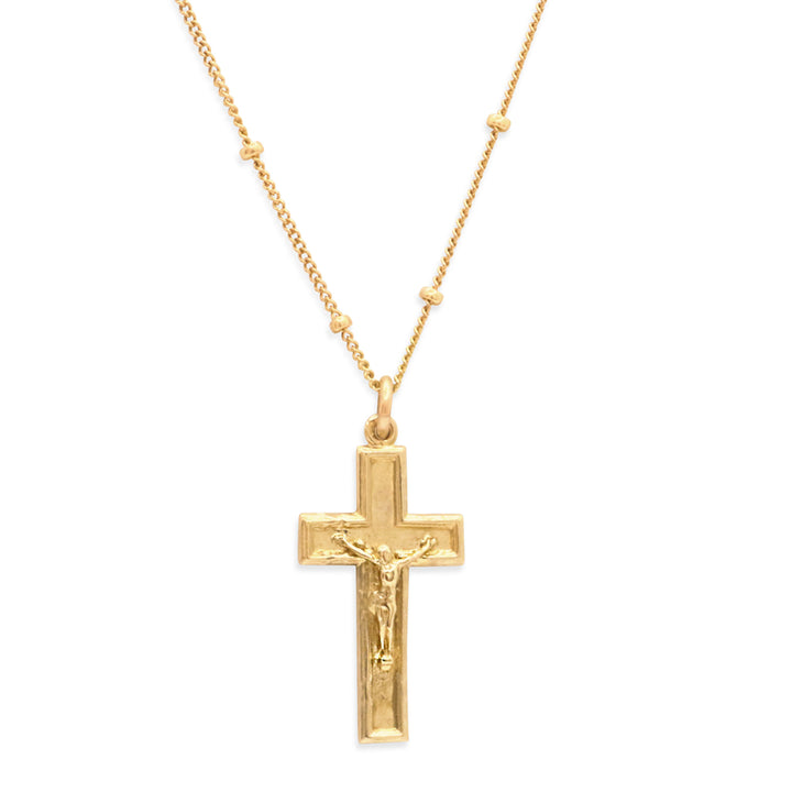 Gold crucifix pendant necklace on a white background
