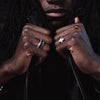 Close-up of a person wearing two rings on a dark background