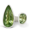 Green gemstone ring with silver setting on a white background