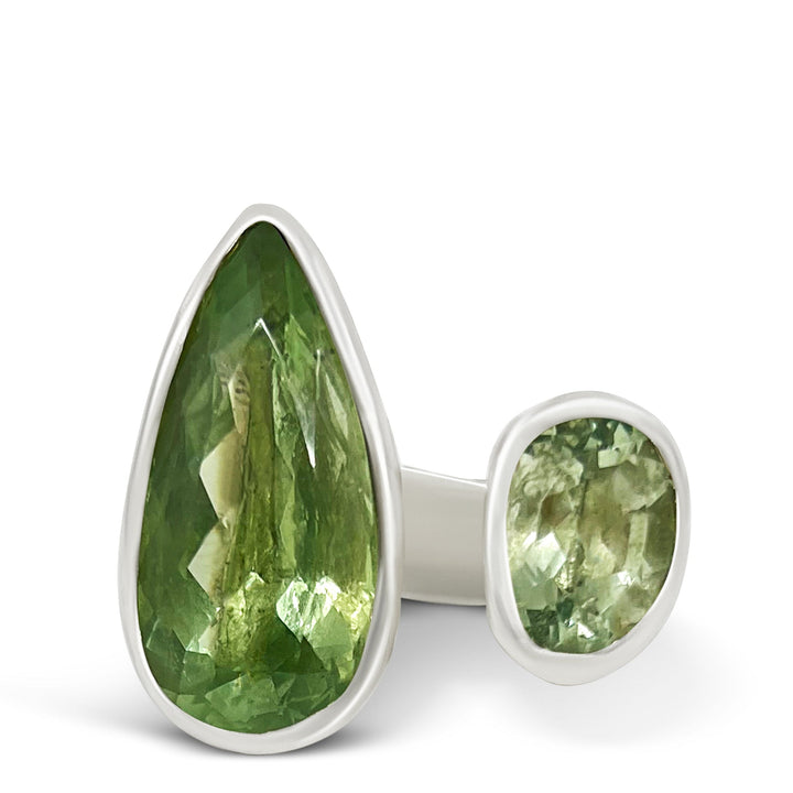 Green gemstone ring with silver setting on a white background