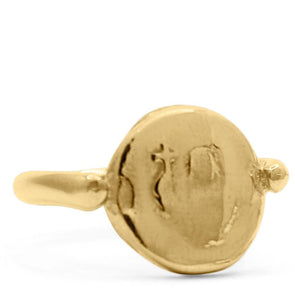 14k yellow gold signet ring which is a coin with a thin band. The coin has an image of an abstract mother mary with a cross engraved in it. shot on white background