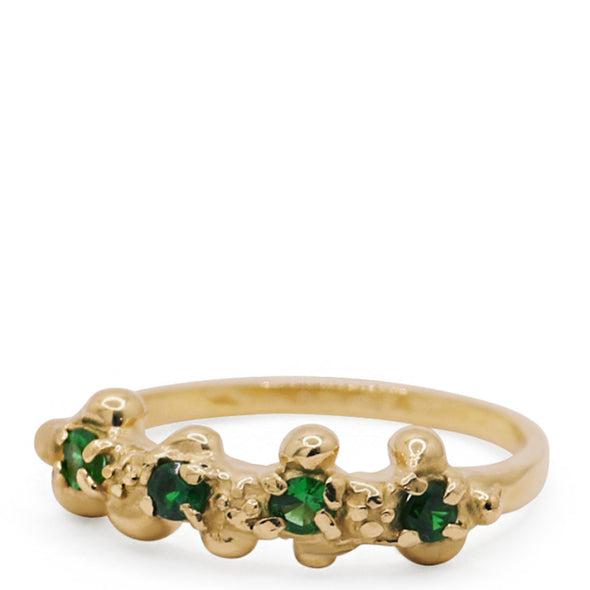 Gold ring with green gemstones on a white background