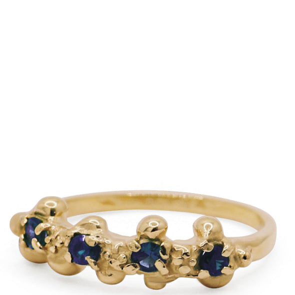 Gold ring with blue gemstones on a white background