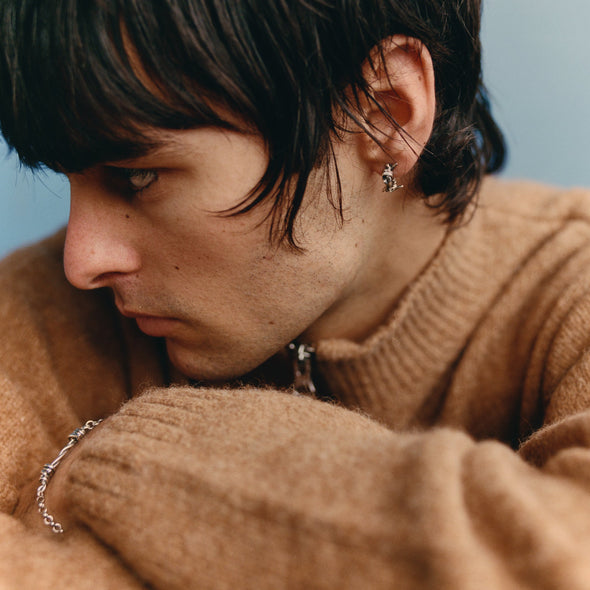 Close-up of a person wearing a brown sweater with a blurred background