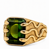A gold signet ring featuring a large, rectangular emerald-cut green gemstone, with a textured gold band designed to look like flames rising from the sides.
