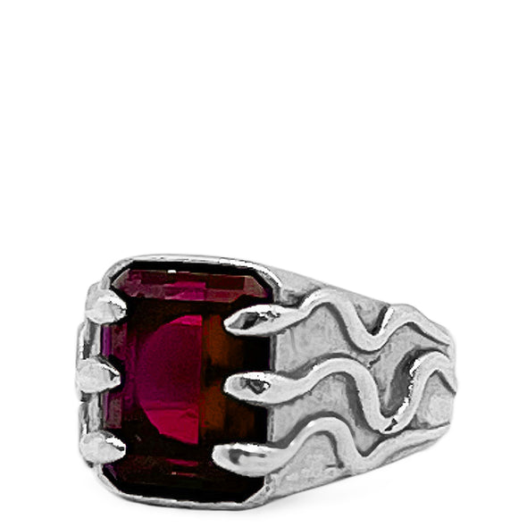 Silver ring with a red gemstone on a white background