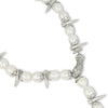 Bracelet with pearls and silver spikes on a white background