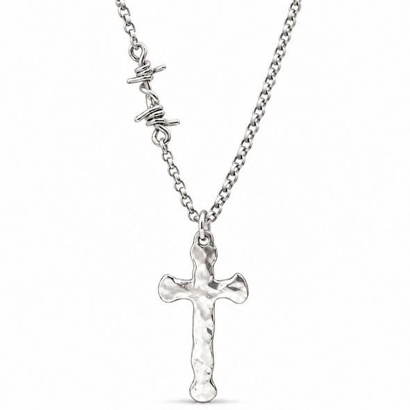 A silver cross pendant necklace with a textured finish, hanging from a silver cable chain with a small script charm on a white background.