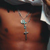 A sterling silver cross pendant necklace with a hammered finish on a heavy Rolo chain featuring a single barbed wire link.